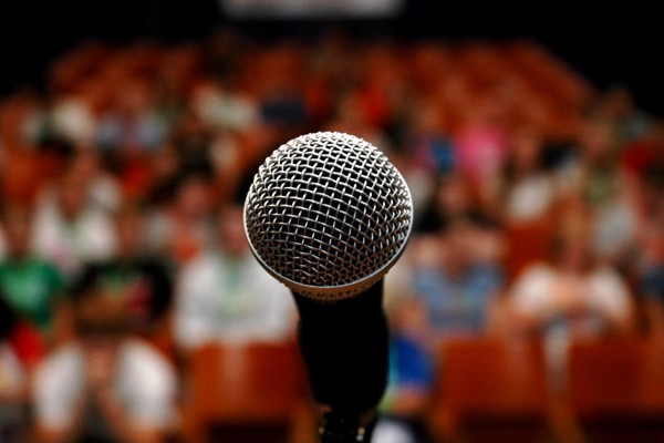 An image of a black microphone on the stage in corporate event